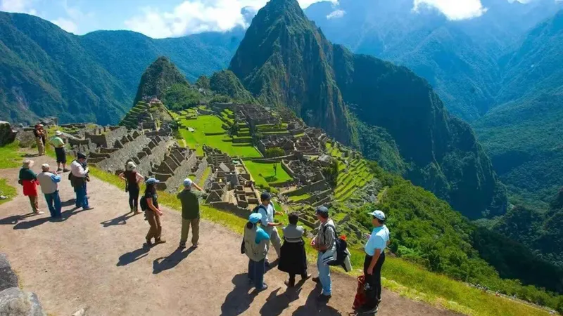 Small guided group at the Machu Picchu citadel overlook above Aguas Calientes, Peru