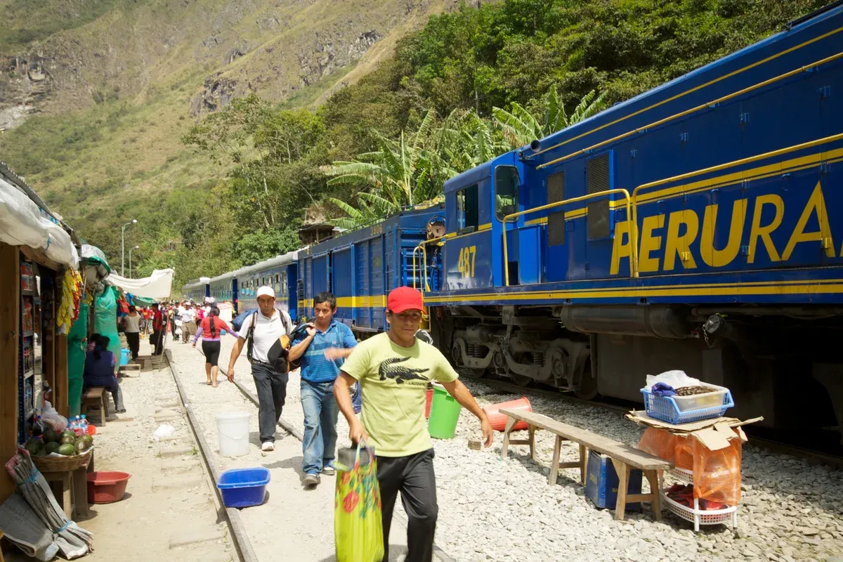 Trekkers walking the flat rail-side path from Hidroelectrica station toward Aguas Calientes, Peru